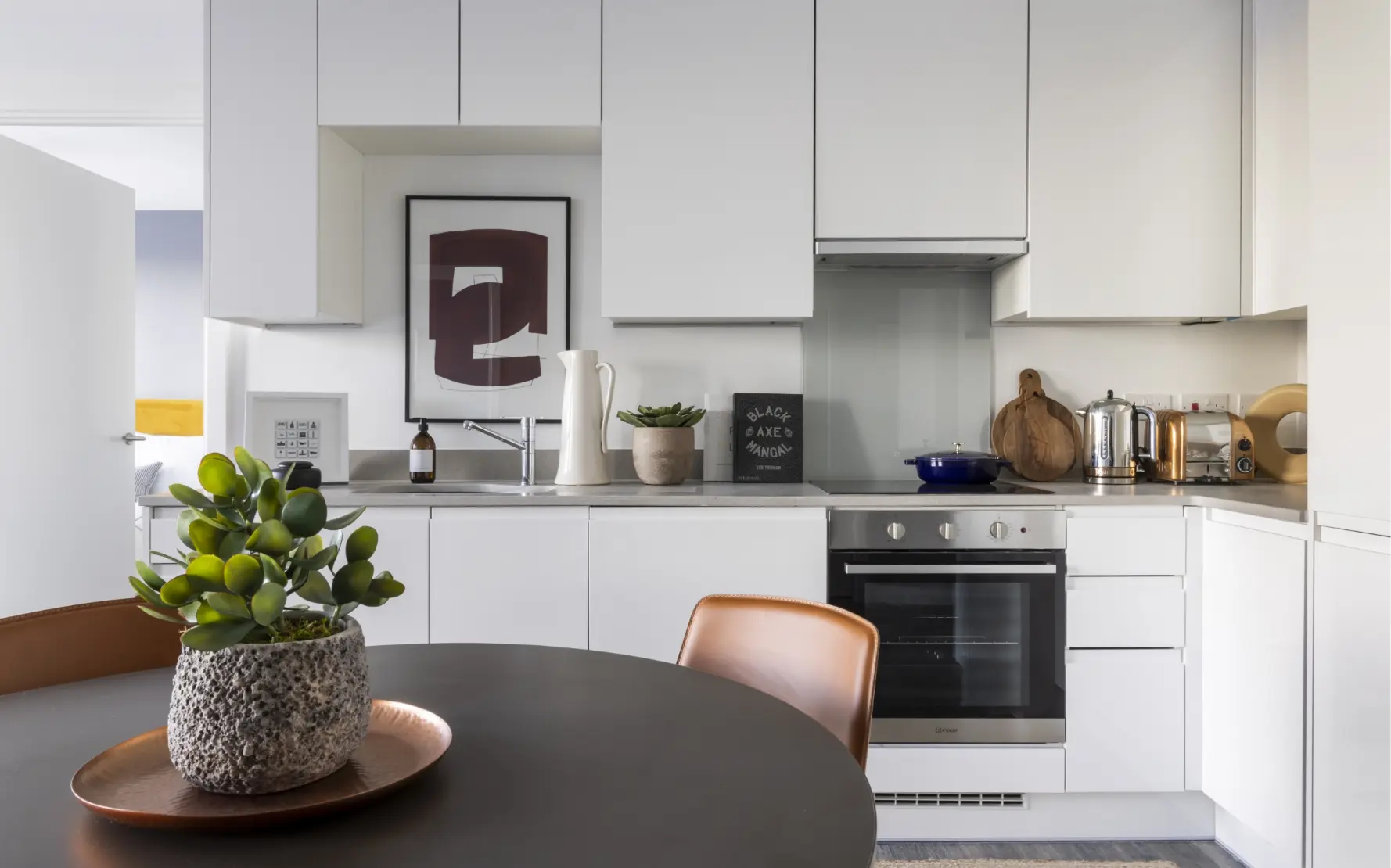 Kitchen table with pot plant and kitchen behind