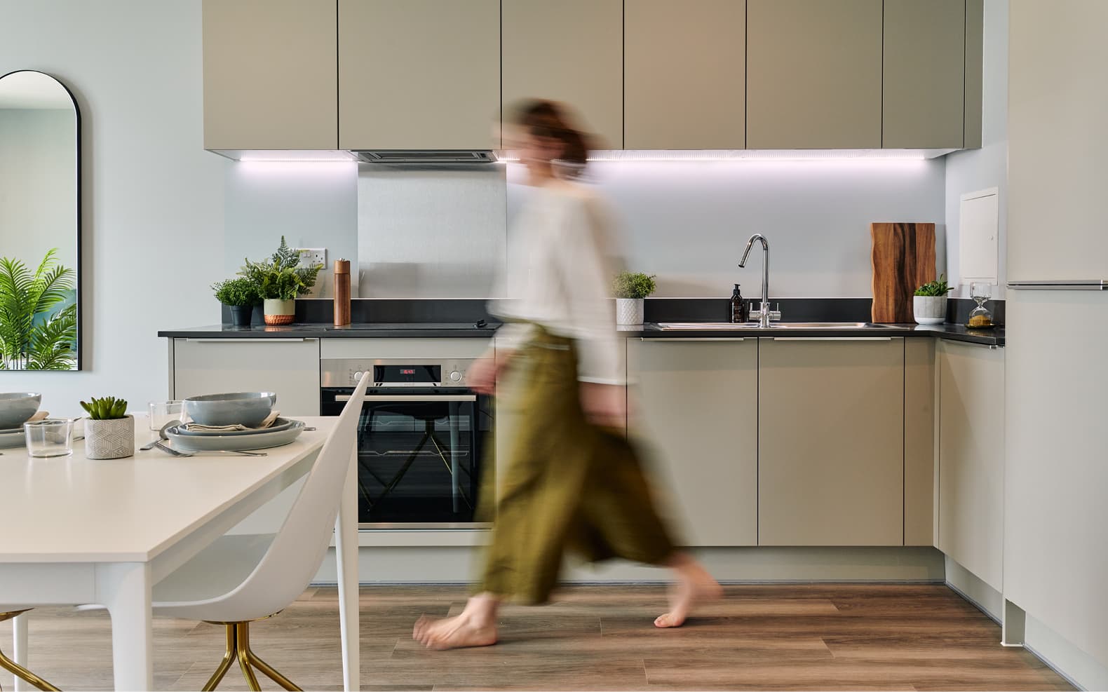kitchen with table and chairs and person walking through